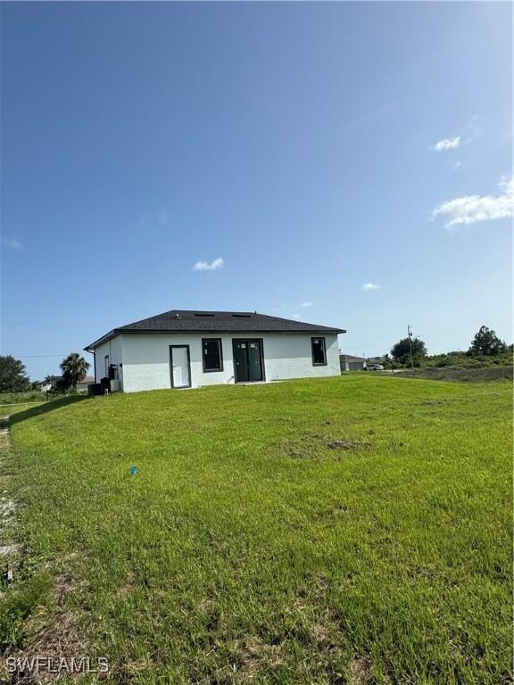 3204 20th St SW, Lehigh Acres, FL 33976 - back of property with a lawn