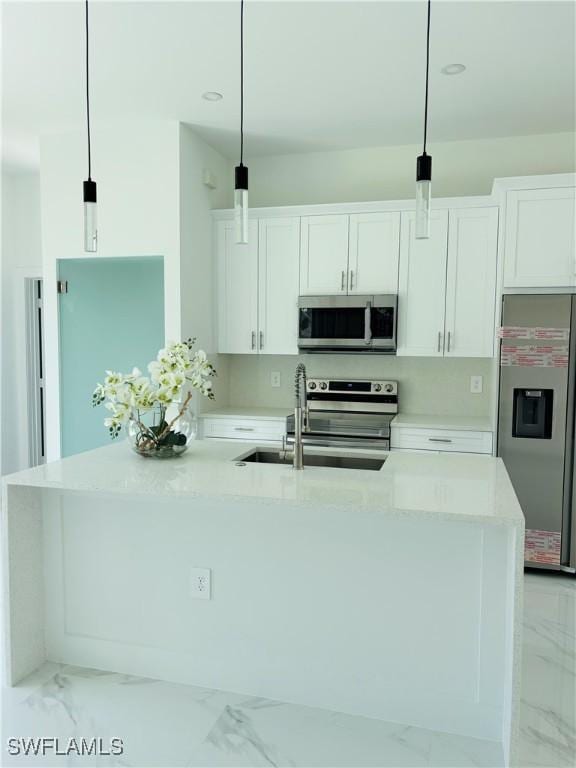 3204 20th St SW, Lehigh Acres, FL 33976 - kitchen with appliances with stainless steel finishes, light marble finish flooring, white cabinets, an island with sink, and recessed lighting
