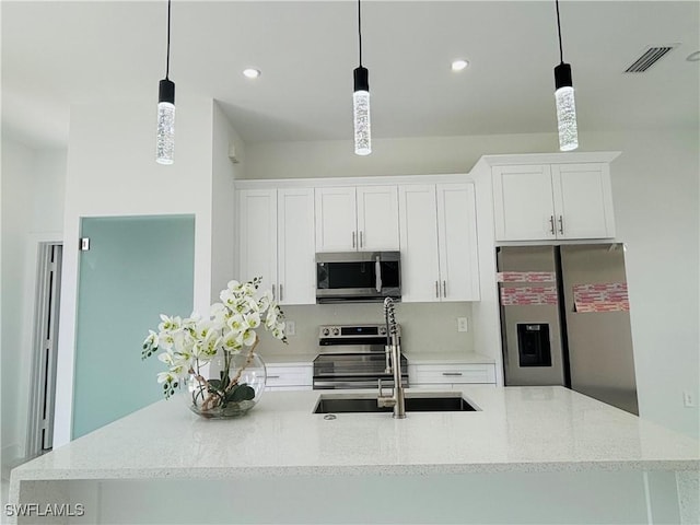 3204 20th St SW, Lehigh Acres, FL 33976 - kitchen featuring appliances with stainless steel finishes, a kitchen island with sink, white cabinets, hanging light fixtures, and recessed lighting