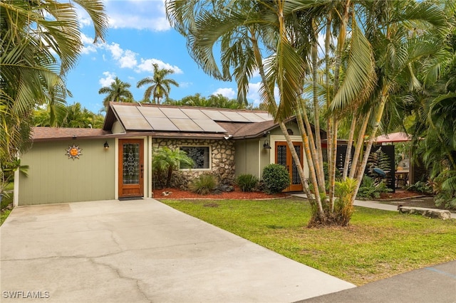 view of front of house featuring solar panels and a front yard