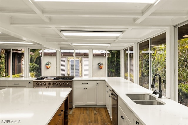 kitchen featuring dark wood-type flooring, sink, light stone counters, and white cabinets