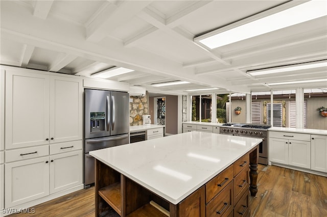 kitchen featuring a center island, kitchen peninsula, white cabinetry, appliances with stainless steel finishes, and dark hardwood / wood-style flooring