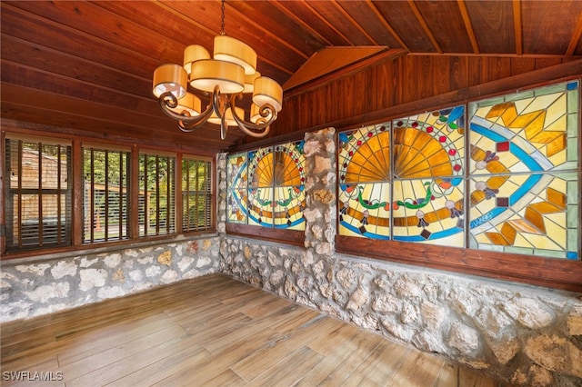 spare room featuring an inviting chandelier, wood ceiling, lofted ceiling, and hardwood / wood-style flooring