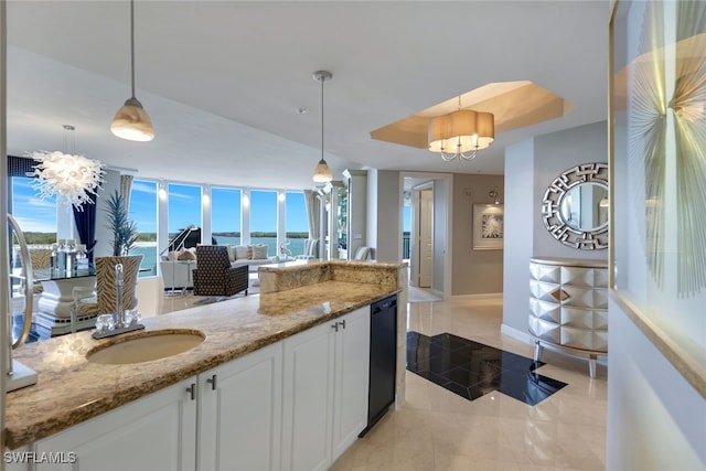 kitchen with a water view, white cabinets, light stone countertops, and pendant lighting