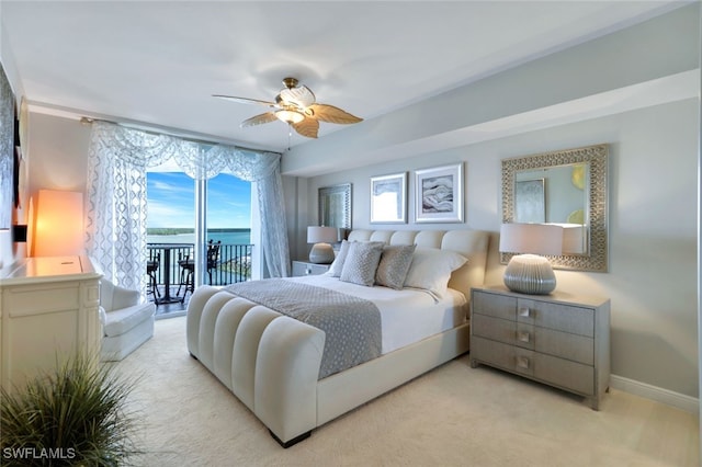 bedroom featuring light carpet, ceiling fan, a water view, and access to outside