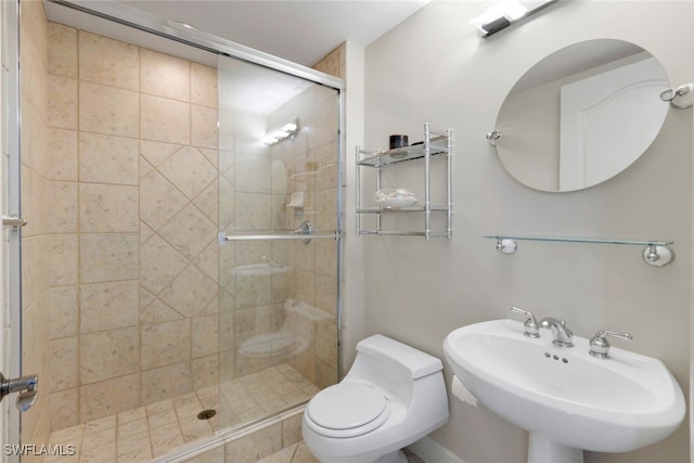 bathroom featuring sink, an enclosed shower, and toilet