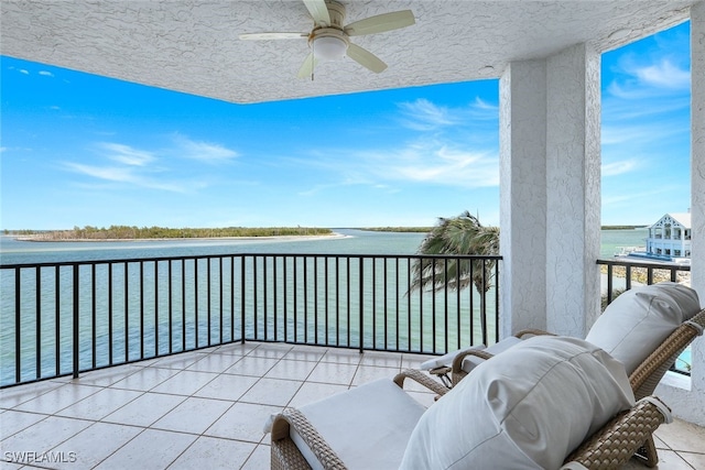 balcony featuring a water view and ceiling fan