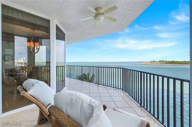 balcony with ceiling fan and a water view