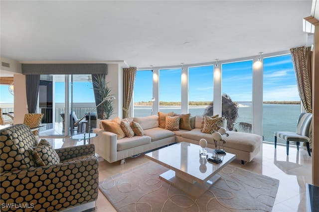 tiled living room with floor to ceiling windows and a water view