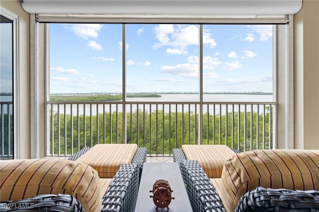 sunroom / solarium featuring a water view and a wealth of natural light