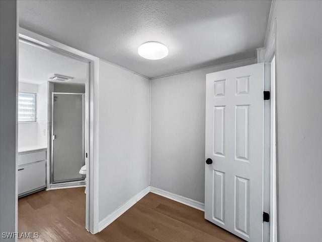 hall featuring a textured ceiling and hardwood / wood-style floors