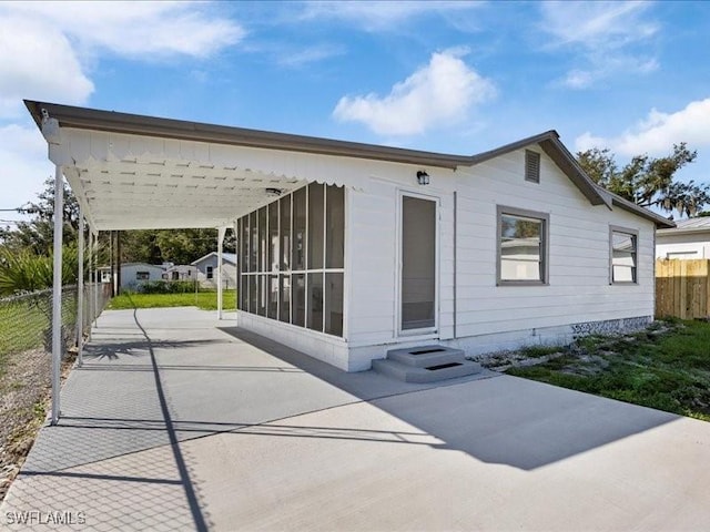 view of front facade with a carport and a sunroom