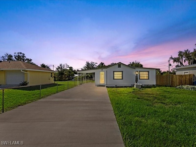 single story home featuring a carport and a yard