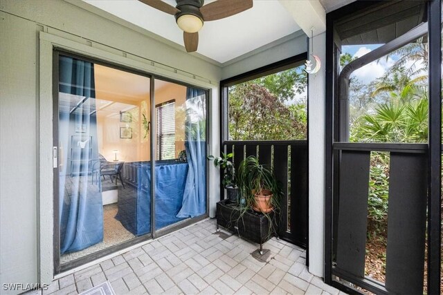 unfurnished sunroom with ceiling fan