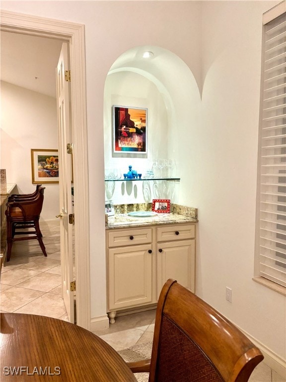 bar featuring a dry bar and light tile patterned flooring