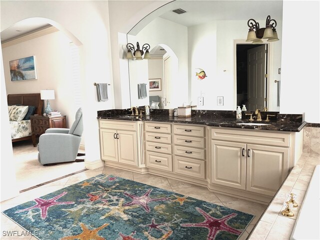 ensuite bathroom featuring visible vents, a sink, and double vanity