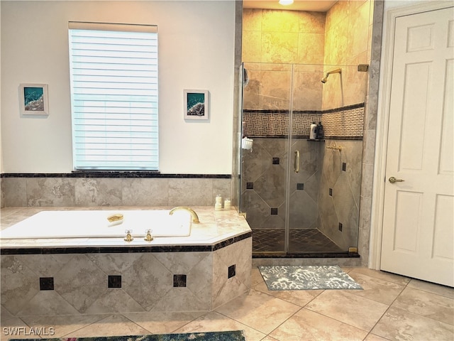 bathroom with a shower stall, a bath, and tile patterned floors