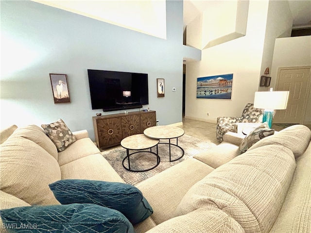 living room with a towering ceiling and baseboards