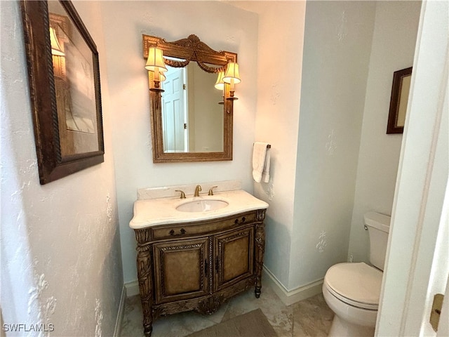 half bath with baseboards, vanity, and toilet