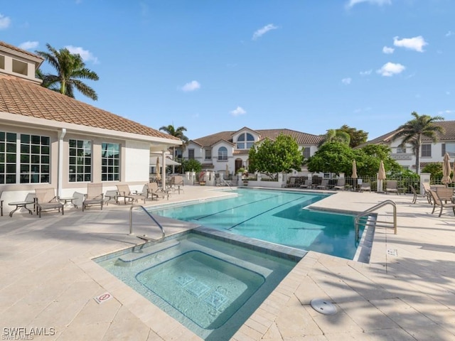 community pool featuring a community hot tub, a patio area, and fence