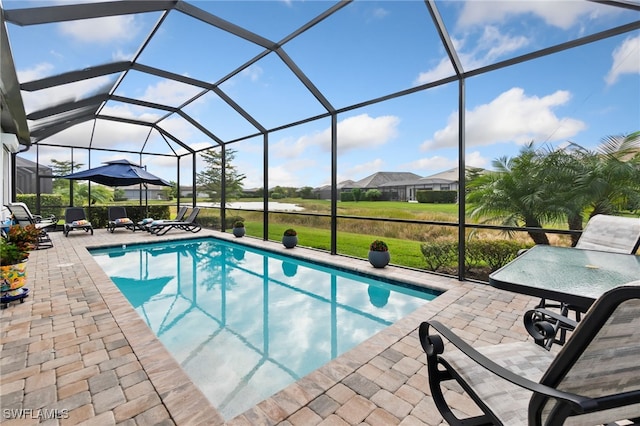 view of swimming pool featuring a lanai, a patio area, and a lawn