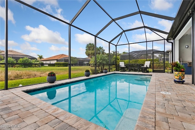 view of pool with a lanai, a lawn, and a patio