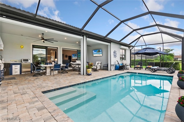 view of swimming pool featuring ceiling fan, area for grilling, a lanai, and a patio