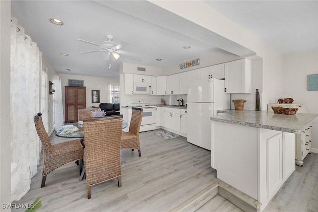 kitchen with kitchen peninsula, sink, white appliances, white cabinetry, and light hardwood / wood-style flooring