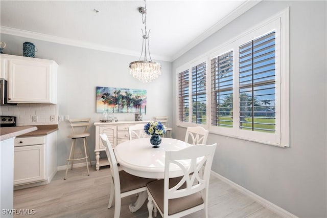 dining space with crown molding, a chandelier, and light wood-type flooring