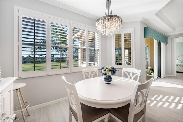 dining room featuring ornamental molding, an inviting chandelier, and light hardwood / wood-style floors