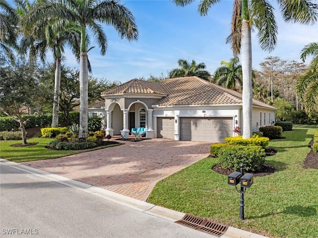 mediterranean / spanish-style house featuring a front lawn and a garage