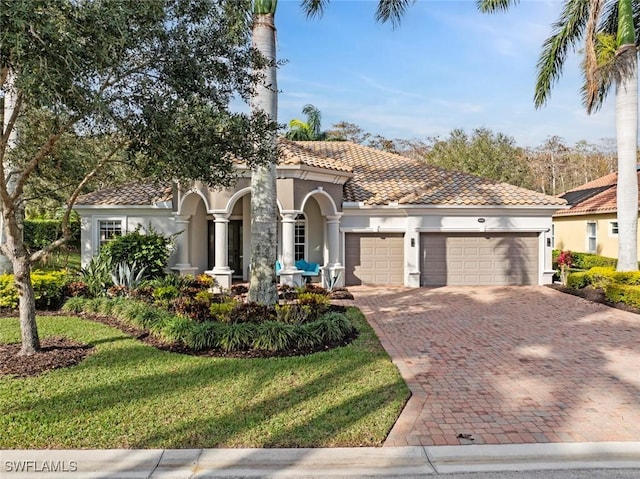 mediterranean / spanish home with a front lawn and a garage