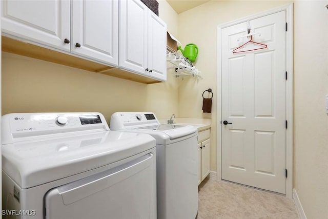 laundry area featuring cabinets, light tile patterned flooring, independent washer and dryer, and sink