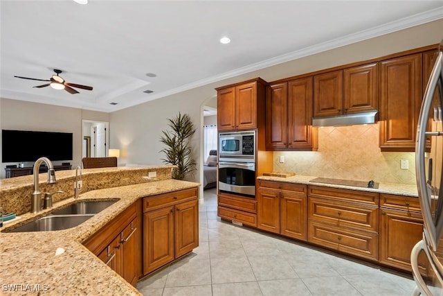 kitchen with light tile patterned floors, stainless steel appliances, light stone countertops, crown molding, and sink