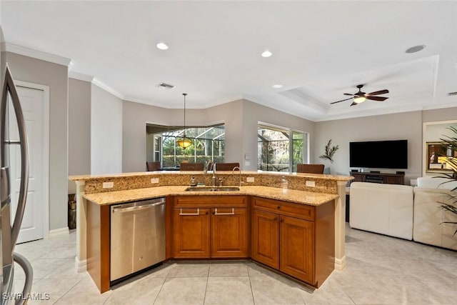 kitchen with light stone countertops, appliances with stainless steel finishes, sink, a raised ceiling, and a center island with sink