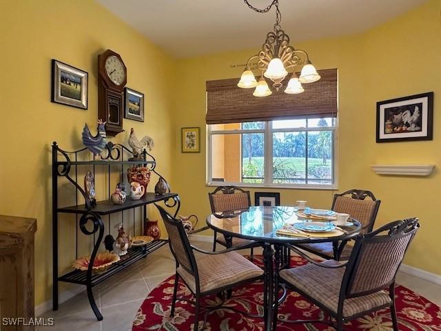 dining room with tile patterned floors and a chandelier