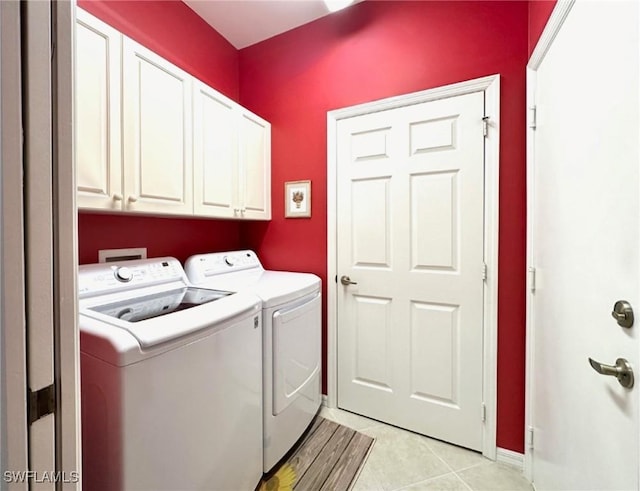 laundry room with cabinets, washing machine and dryer, and light tile patterned floors