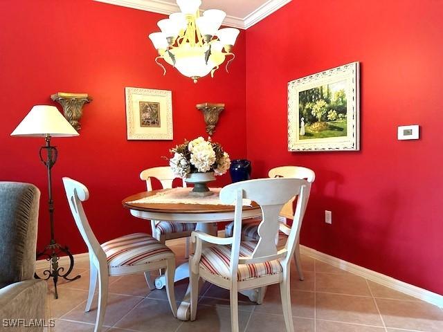 dining room featuring crown molding, tile patterned flooring, and a notable chandelier