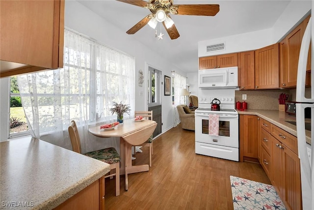 kitchen featuring ceiling fan, white appliances, decorative backsplash, and light hardwood / wood-style flooring