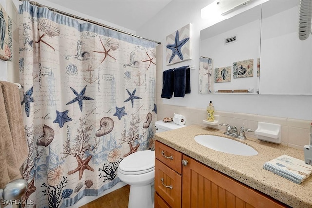 bathroom with toilet, vanity, and walk in shower