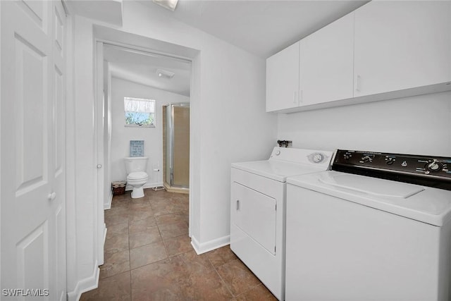 washroom featuring washer and dryer and cabinets