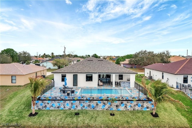 rear view of property with a fenced in pool, a patio area, and a lawn