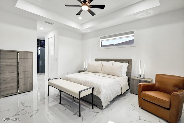 bedroom with ceiling fan and a tray ceiling