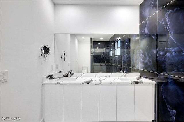 bathroom with vanity, a shower with shower door, and toilet