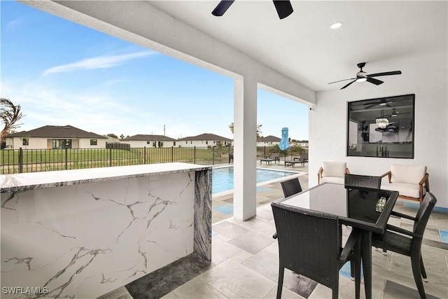 view of patio / terrace featuring a fenced in pool and ceiling fan