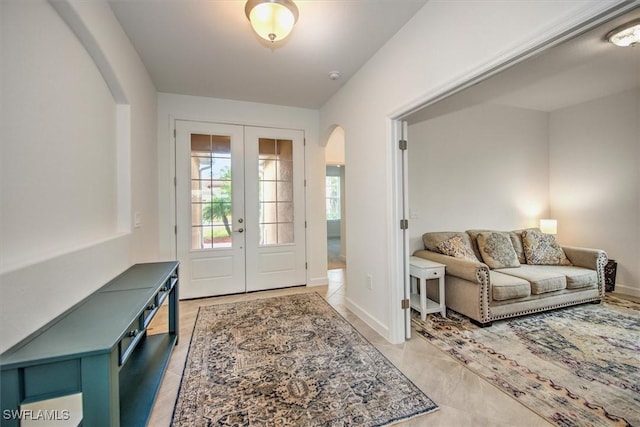 entryway with light tile patterned floors and french doors