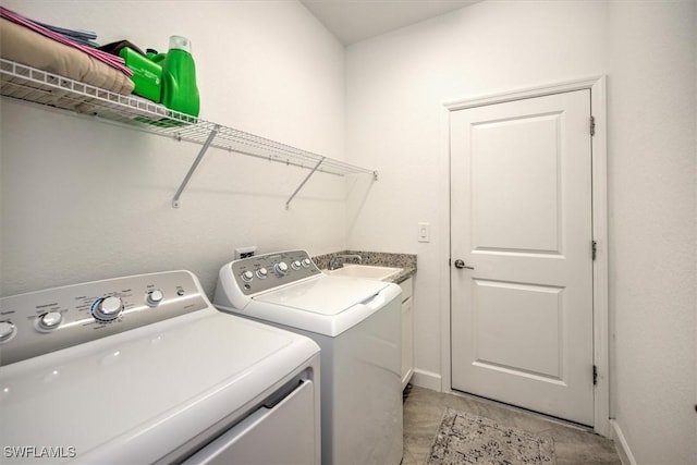 washroom featuring sink, cabinets, washing machine and clothes dryer, and light tile patterned flooring