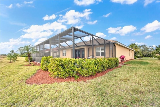 back of house featuring a lanai and a yard