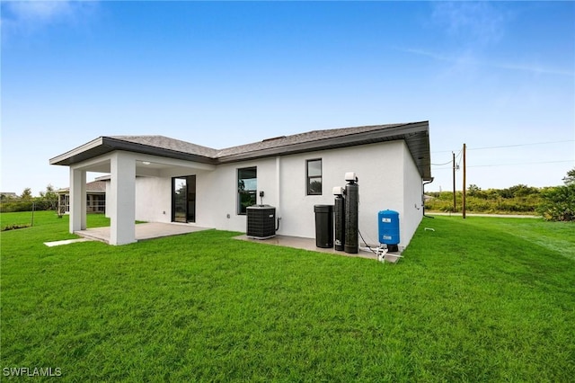 back of house with a lawn, cooling unit, and a patio