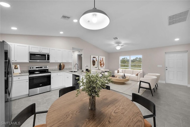 dining room featuring ceiling fan, sink, light tile patterned floors, and lofted ceiling